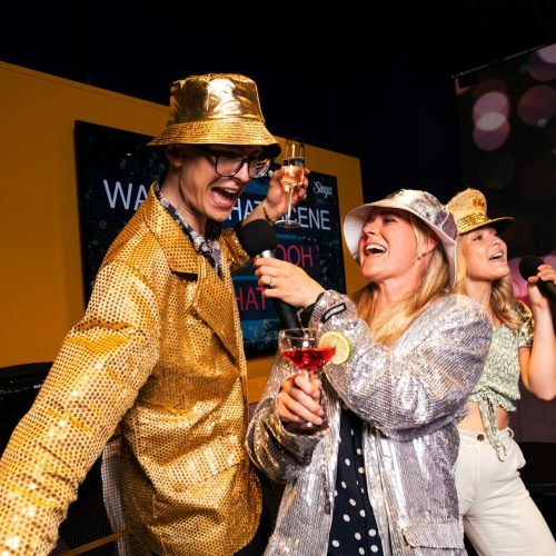 People are partying and singing karaoke with microphones.