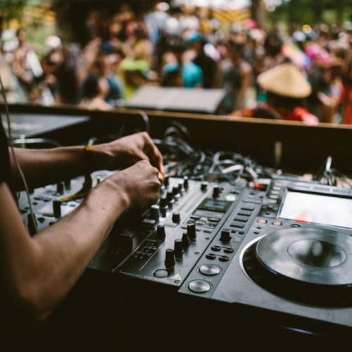 person playing dj mixer in tilt shift lens